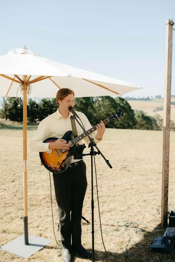 Jem Pryse playing acoustic guitar at a wedding ceremony