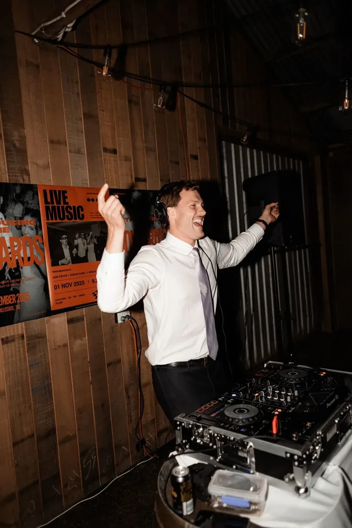 Jem Pryse DJing with his arms in the air at a wedding