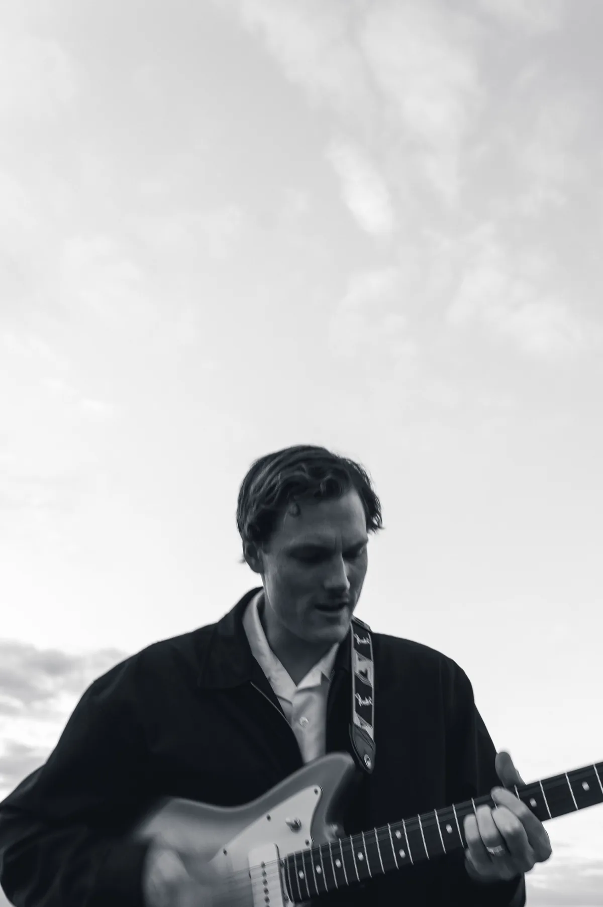 Black and white photo of Jem Pryse playing guitar