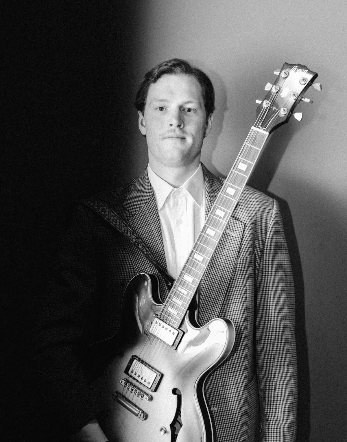 Black and white portrait of Jem Pryse holding a guitar