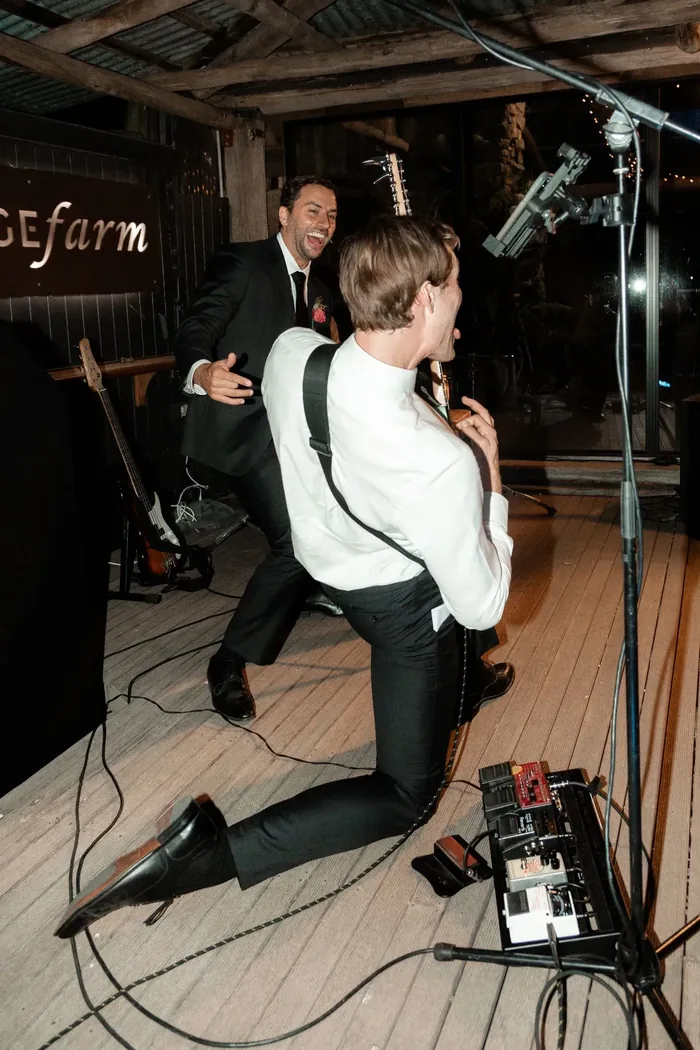 Jem Pryse performing with a guitar at a wedding reception