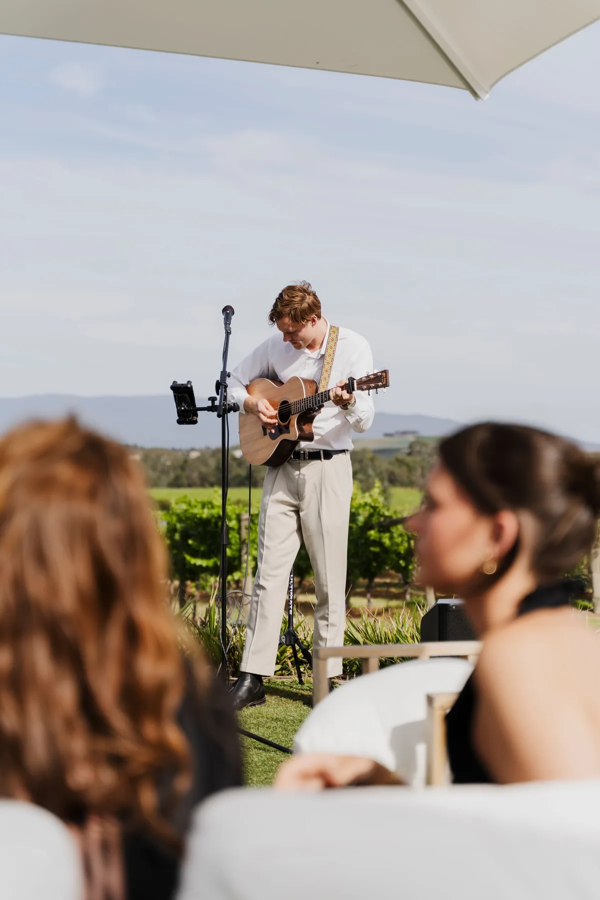 Jem Pryse playing acoustic guitar at a wedding ceremony